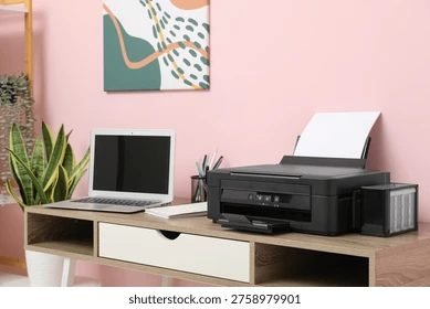 Home printer and laptop on a desk in a home office