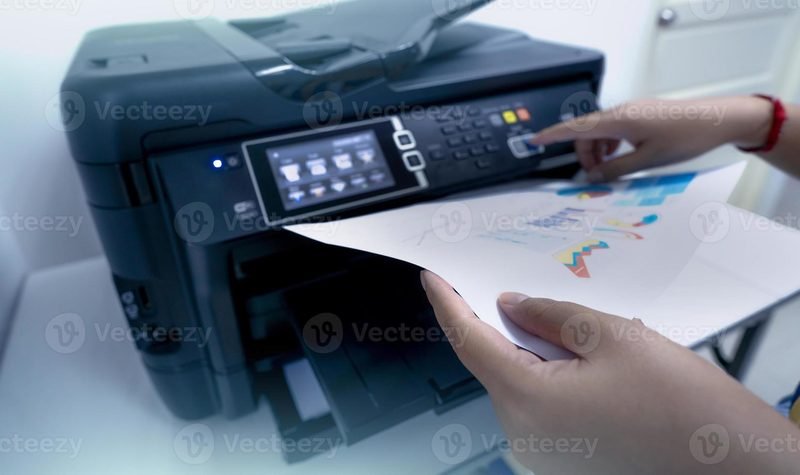 Office worker printing documents on a multifunction laser printer